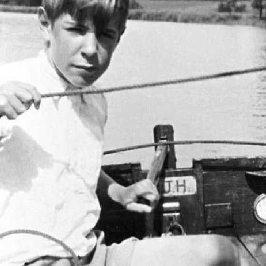 Teenager Hawking steering a boat 