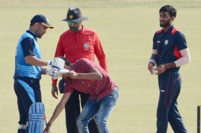 Fan invades pitch, Dhoni obliges with an autograph