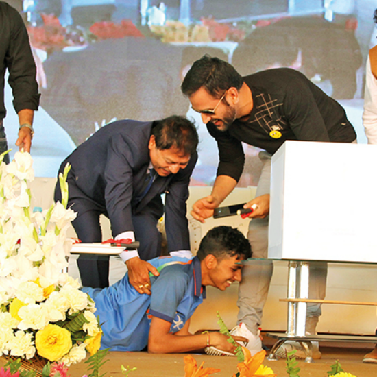 During an event in Lucknow, a fan ran onto the stage to touch Dhoni's feet