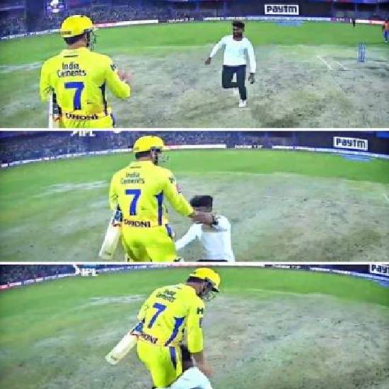 Fan falls to Dhoni's feet