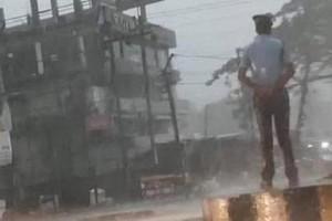 Watch Video: Traffic police gets praised for standing on duty amid storm and rain