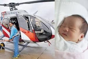 Newborn surrogate baby descended from the skies in an air ambulance; received by the parents