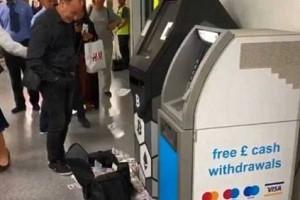 ATM machine throws out cash; people confused 'to pick' or 'watch'