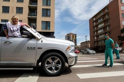 healthcare workers stare at anti-lockdown protesters dramatic pic