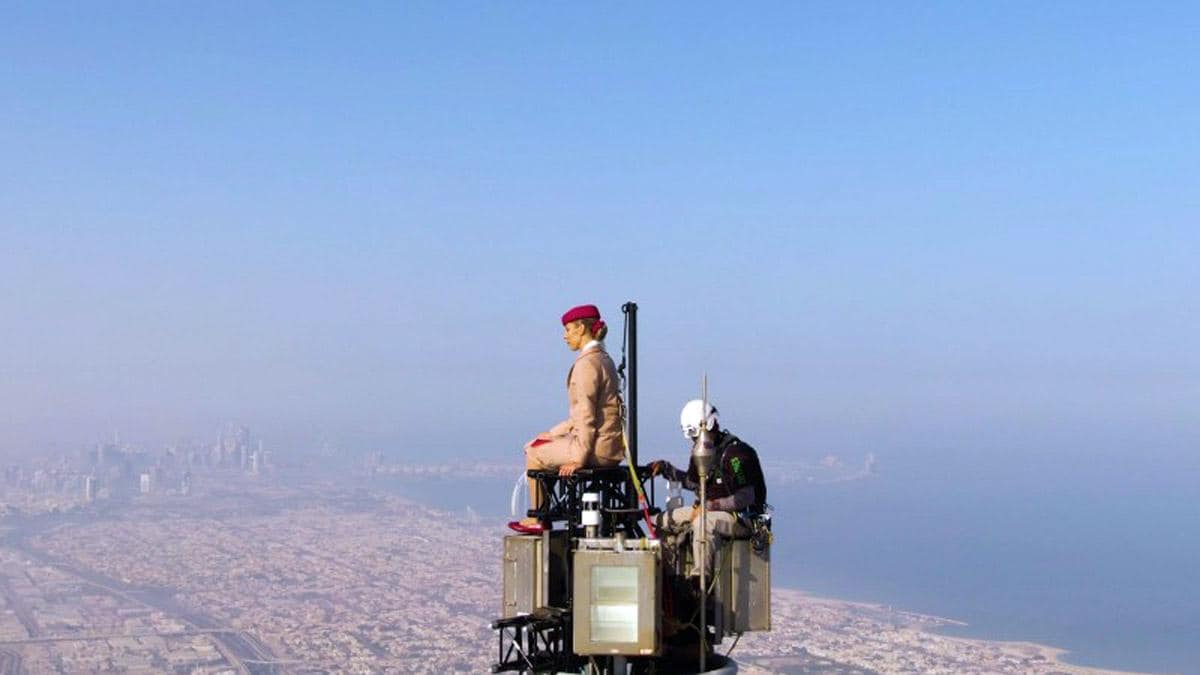 Seorang wanita berdiri di atas Burj Khalifa dalam iklan maskapai penerbangan Emirates. 