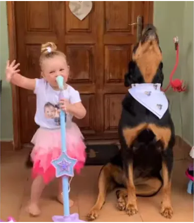Dog and little girl are singing sisters in concert