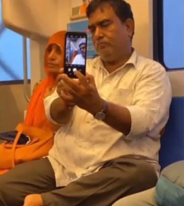 video of a man trying to take a selfie with his wife in a crowded meter