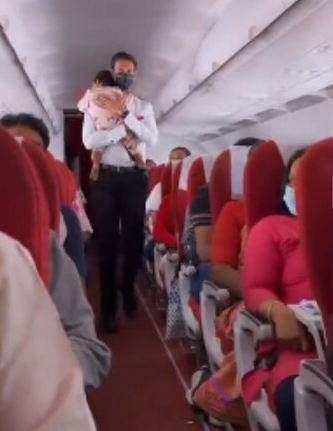 flight attendant consoles crying toddler onboard video